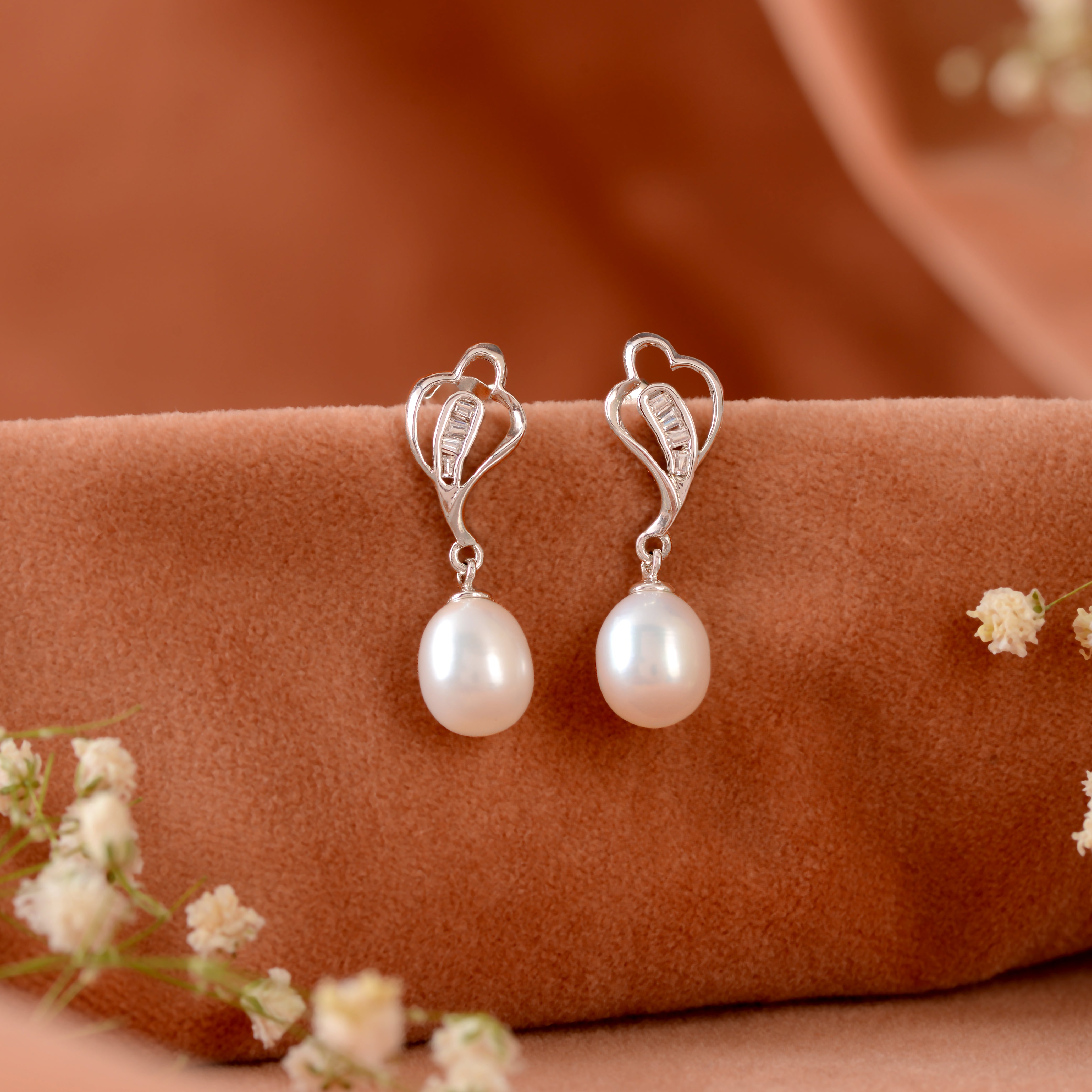 Silver paan leaf earrings with pearls.